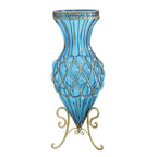 A tall blue glass floor vase with metal flower stand, featuring a geometric pattern on the vase and a gold metal base.